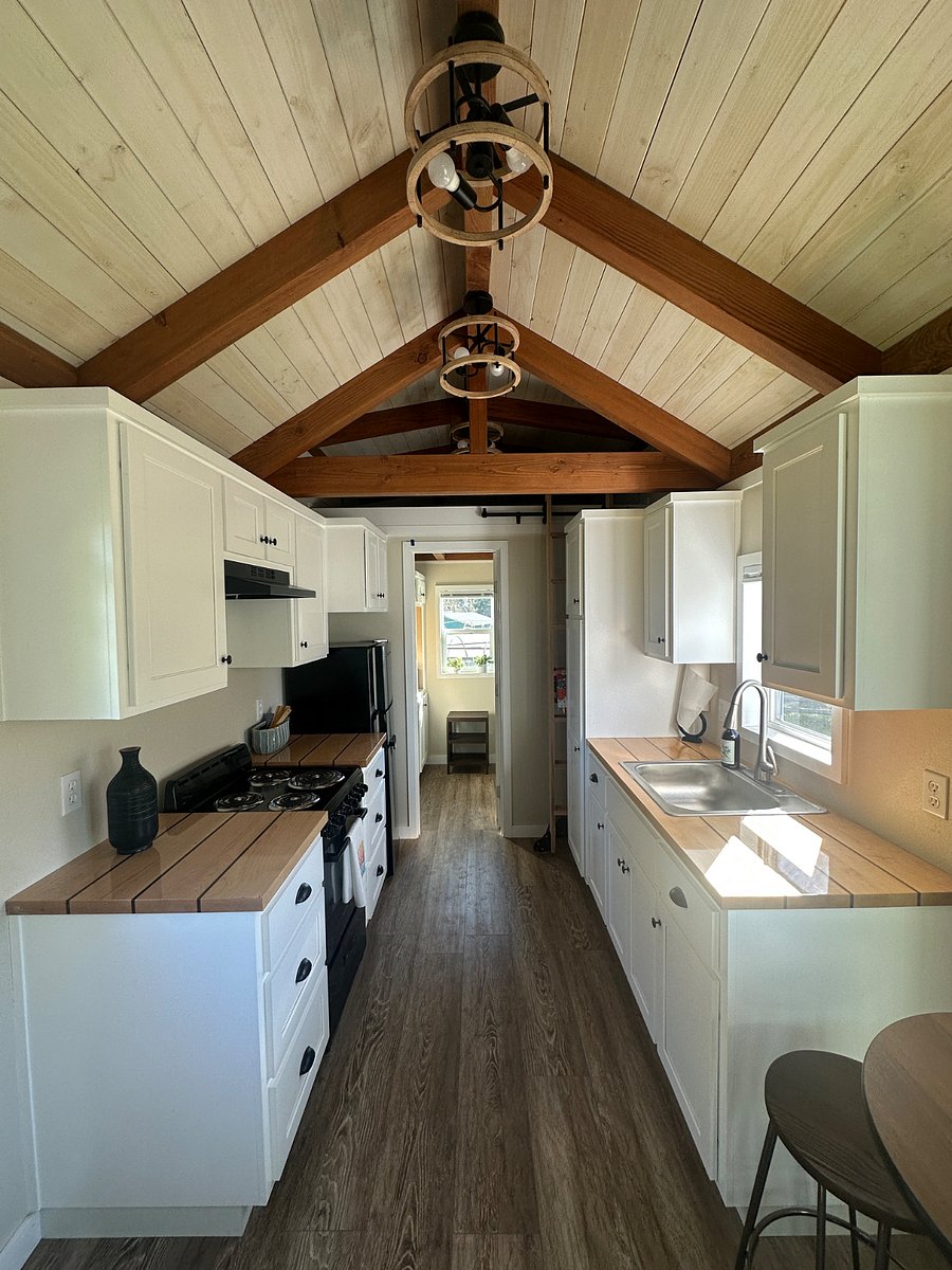 Kitchen leading into bathroom with storage space above bathroom door