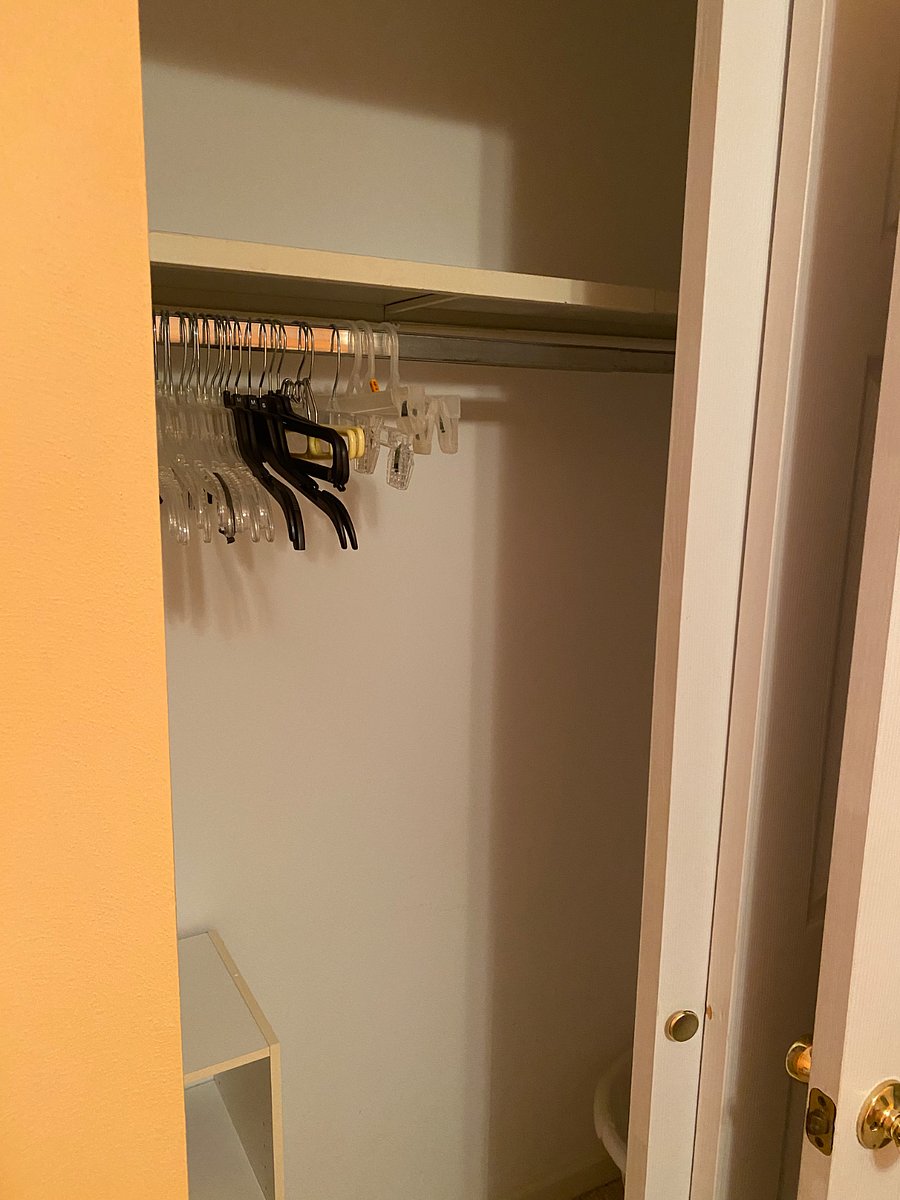 Closet equipped with shelving, hangers and laundry basket