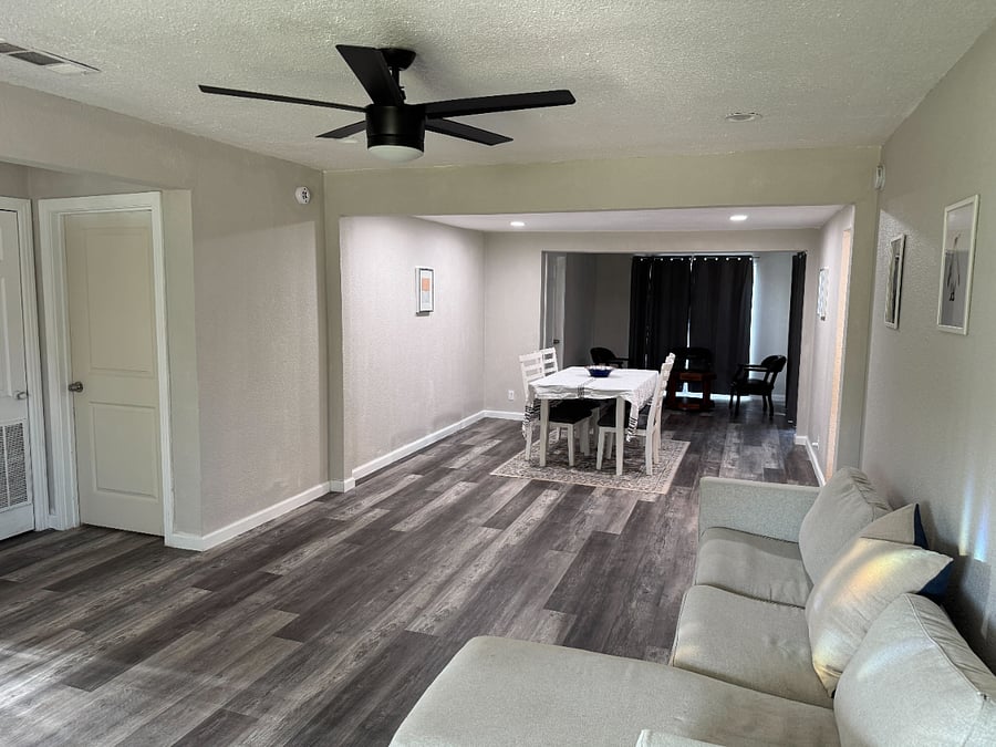 Living room / dining room with a seating area for coffee or tea leading to the backyard and laundry area.