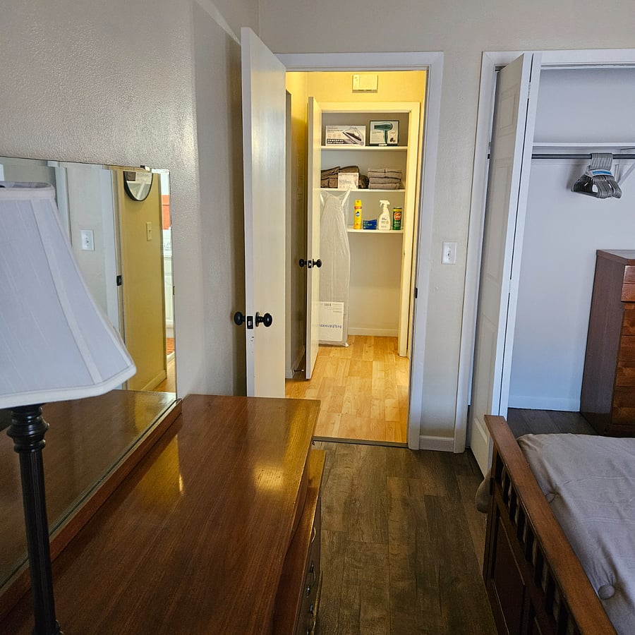 Large linen closet with full size ironing board,new steam iron, hairdryer, extra sheets, cleaning supplies, and towels conveniently located between the bedroom and bathroom. 