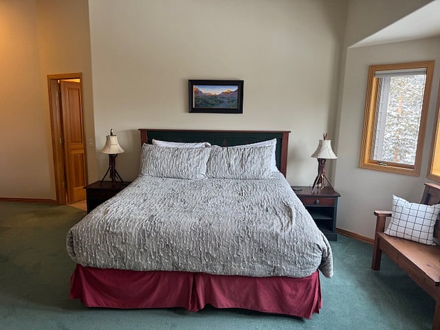 Primary bedroom with king bed, four piece ensuite bathroom and gas fireplace plus bay window for natural light and views of Ten Mile Creek in the back yard.