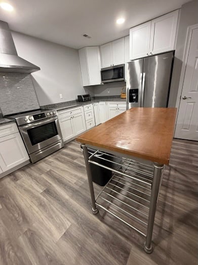 Kitchen stove/oven, toaster oven, microwave oven, and refrigerator.