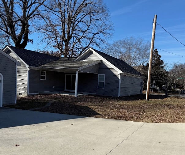 Carriage Cottage. Covered back patio as viewed from the rear driveway. The driveway is accessible from Carriage Rd.