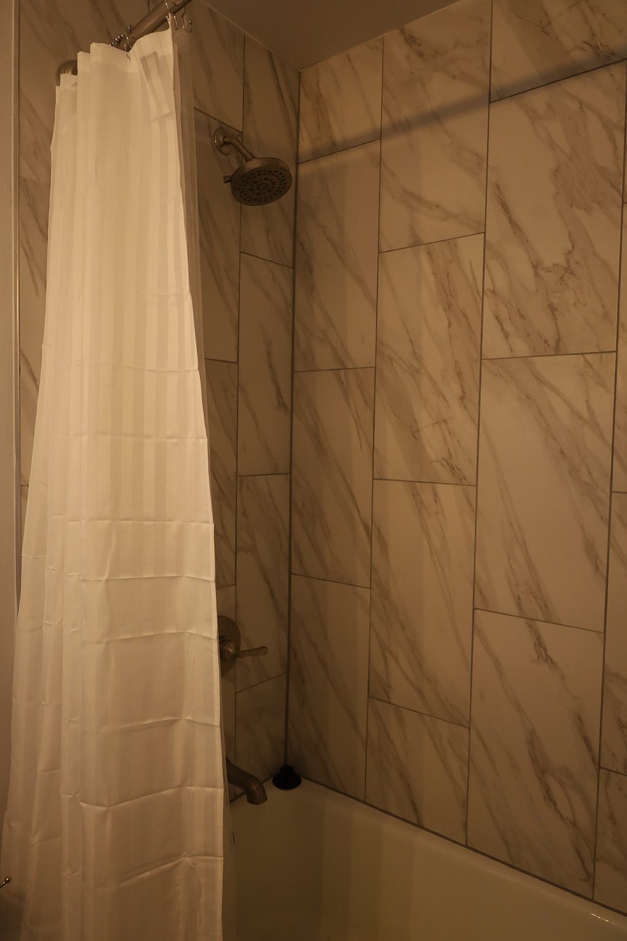 Newly renovated bathroom with tub and shower.