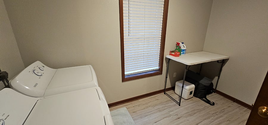 Spacious laundry room with folding table and closet