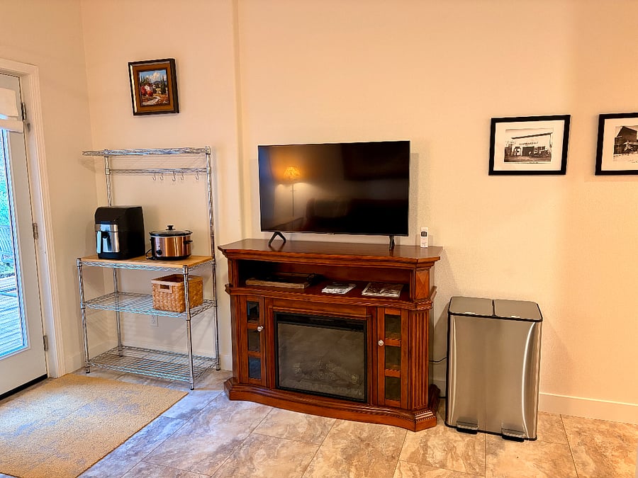 Bakers rack for extra kitchen counter area or can be used for entrance console. 43" Samsung SmartTV with electric fireplace.