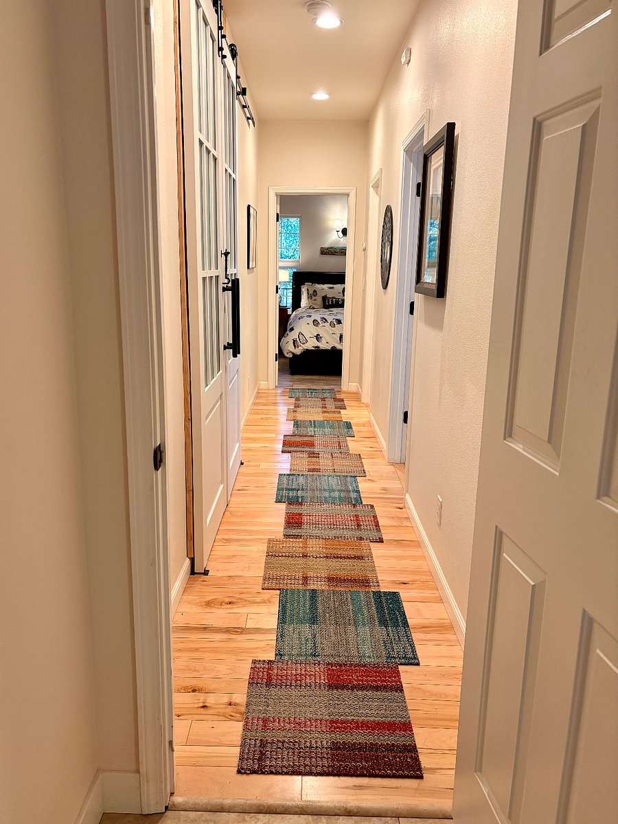 Maple hardwood hallway from kitchenette to first the smaller bedroom, then bath and main bedroom at end.