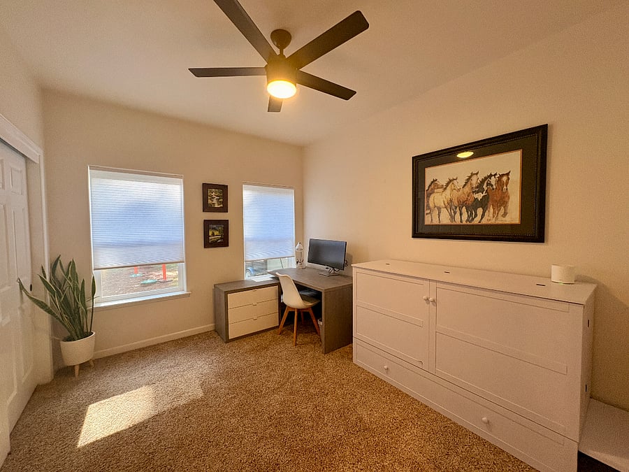 Smaller bedroom with desk and queen cabinet bed.