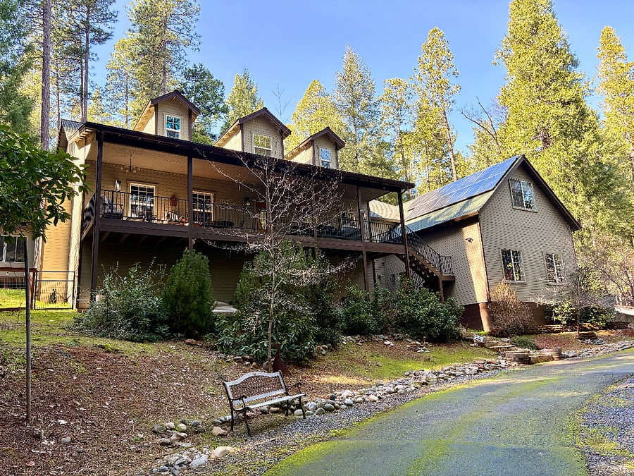 Front of home with in-law suite on left side. Covered front porch is a peaceful place for observing wildlife and having a beverage.