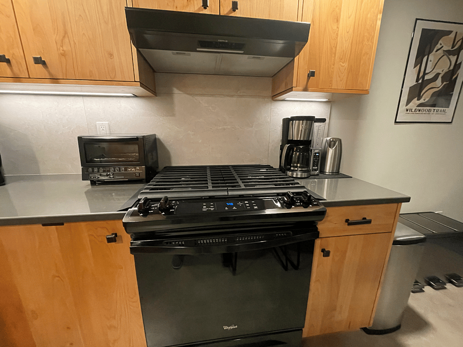 Toaster oven, gas range, vent hood, coffee maker, and electric kettle.