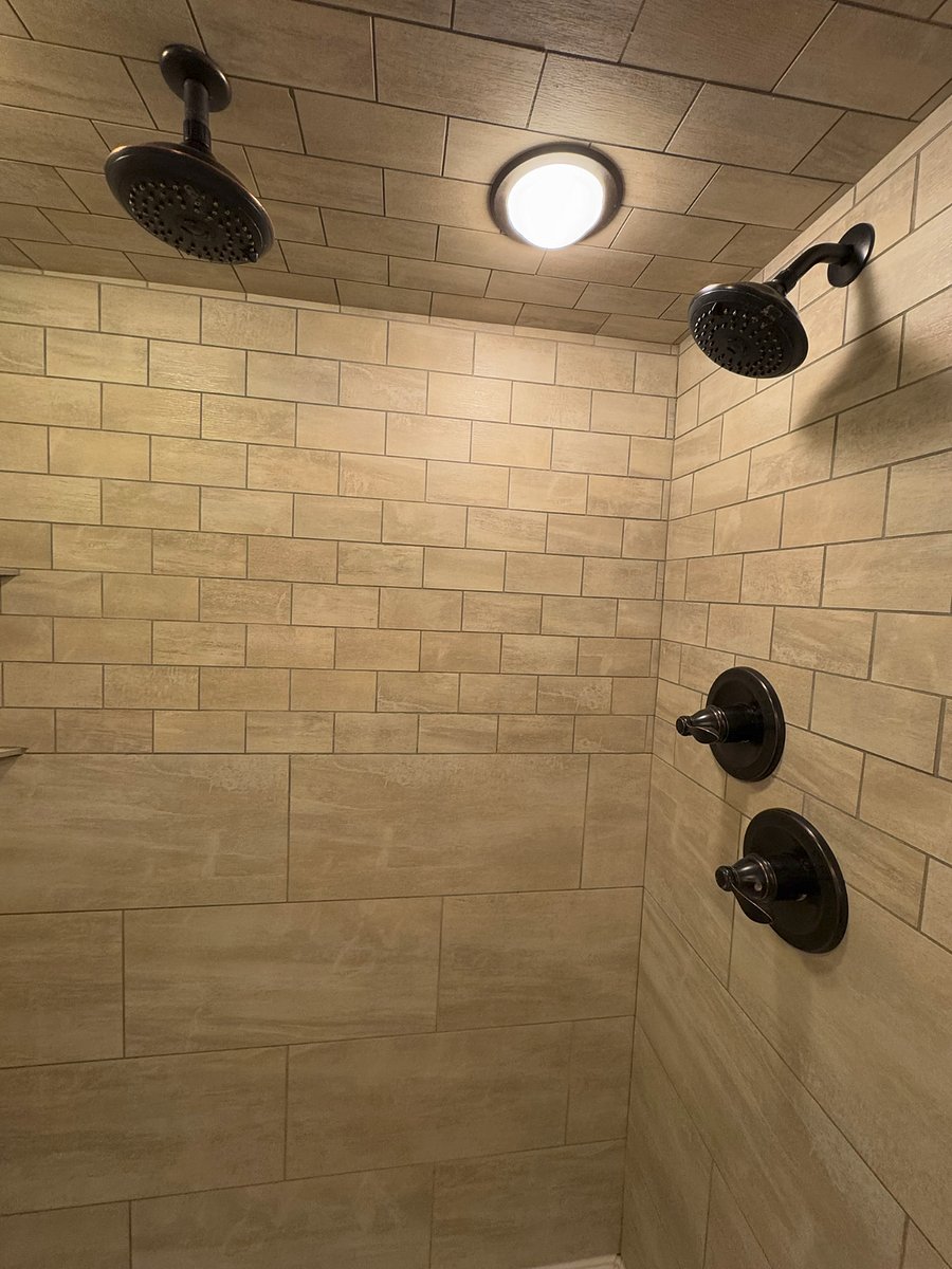 Dual shower head in modern tiled shower. 
