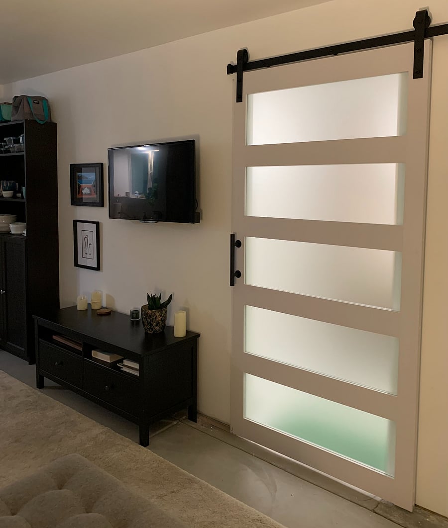Barn-style sliding bathroom door with five glass panels.