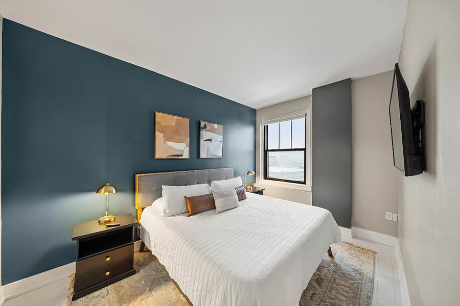 Large King bed in the bedroom with black out curtains and Smart Roku TV.