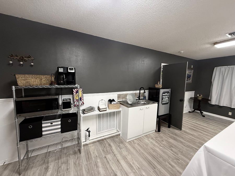 Well-equipped, efficient kitchen featuring a refrigerator, microwave, coffee maker, and toaster, along with all the essentials including plates, cups, utensils, napkins, and potholders everything you need for easy, everyday living