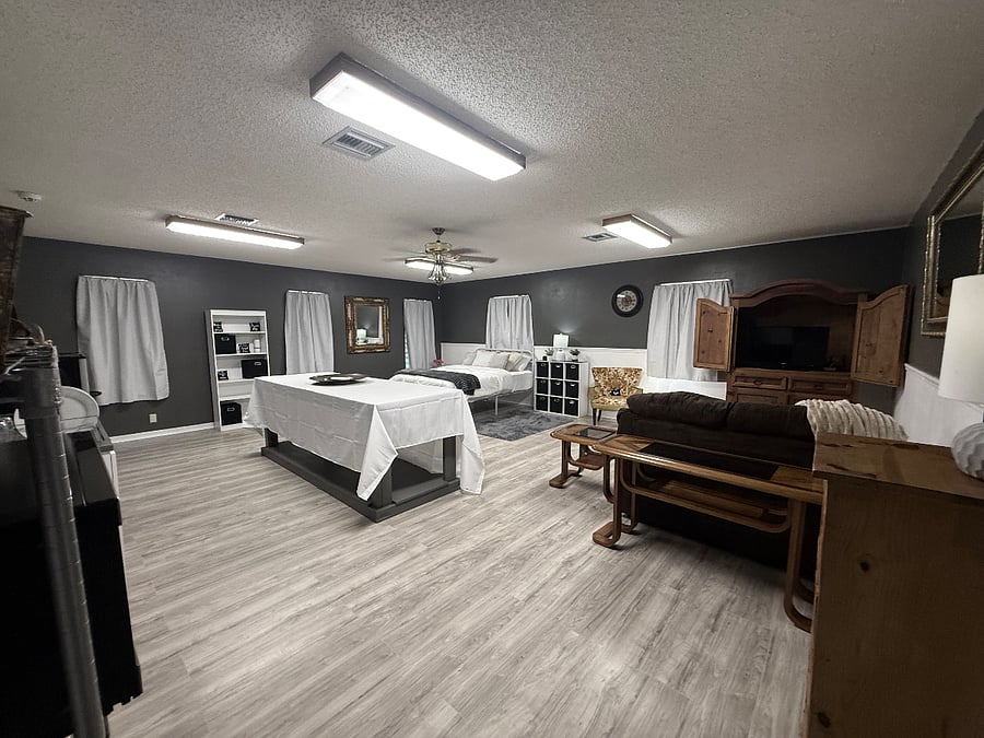 Open-concept layout showcasing the kitchen, sitting area, bedroom, and work table
