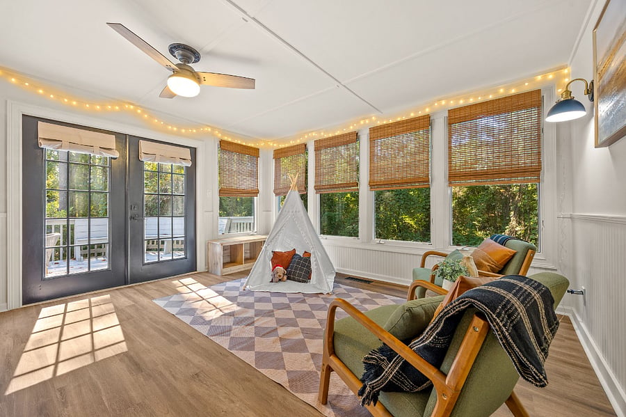 Bright & welcoming Sunroom with lounge chairs and kids corner.