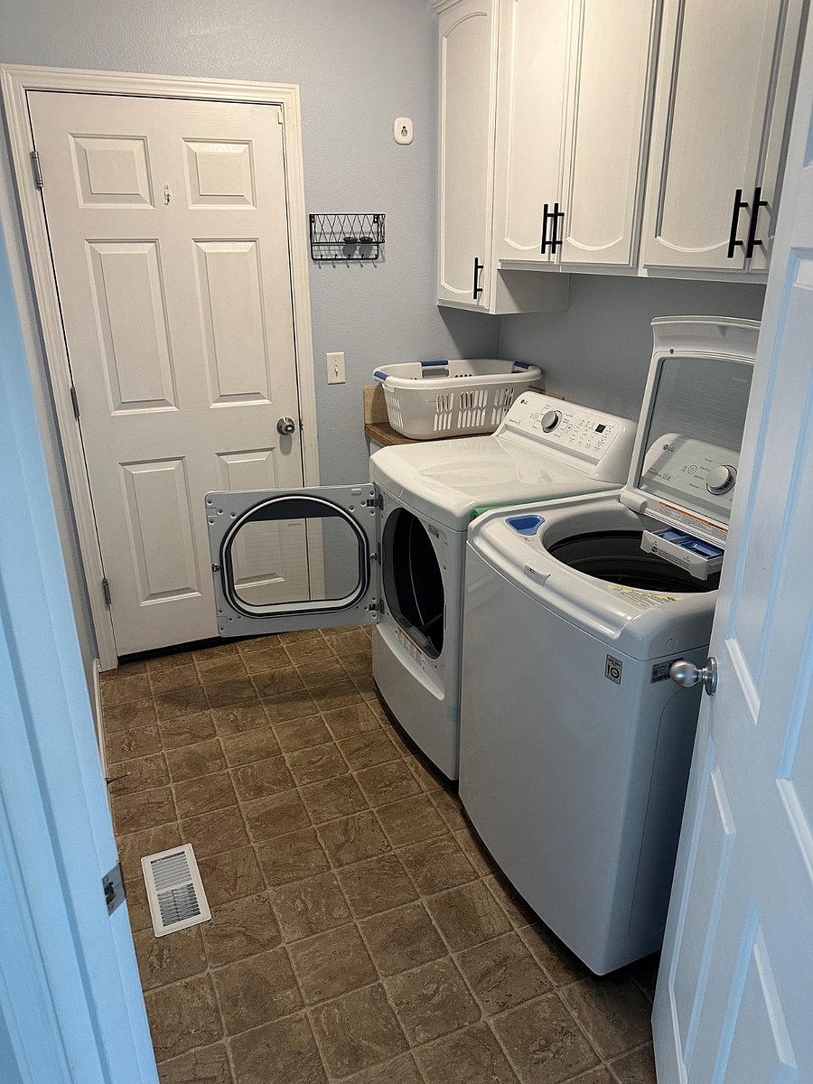 Laundry room with extra storage and door to the garage