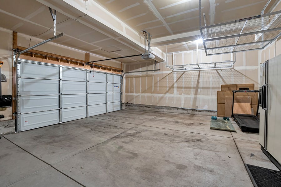 2-car garage with tons of overhead storage, a treadmill and a second fridge