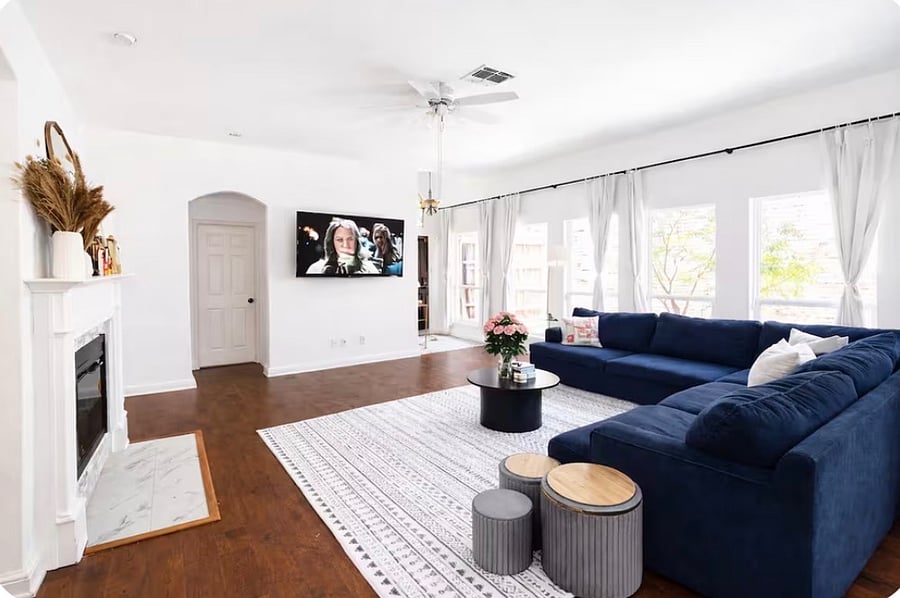The living room features an open space design and a modern, cozy sofa, creating a welcoming area to unwind.