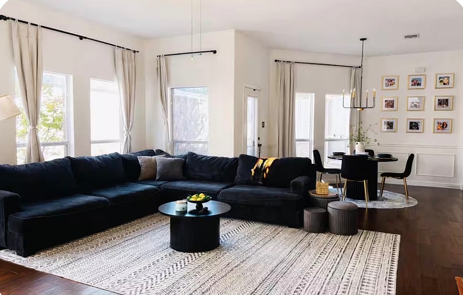 The living room features an open space design and a modern, cozy sofa, creating a welcoming area to unwind.