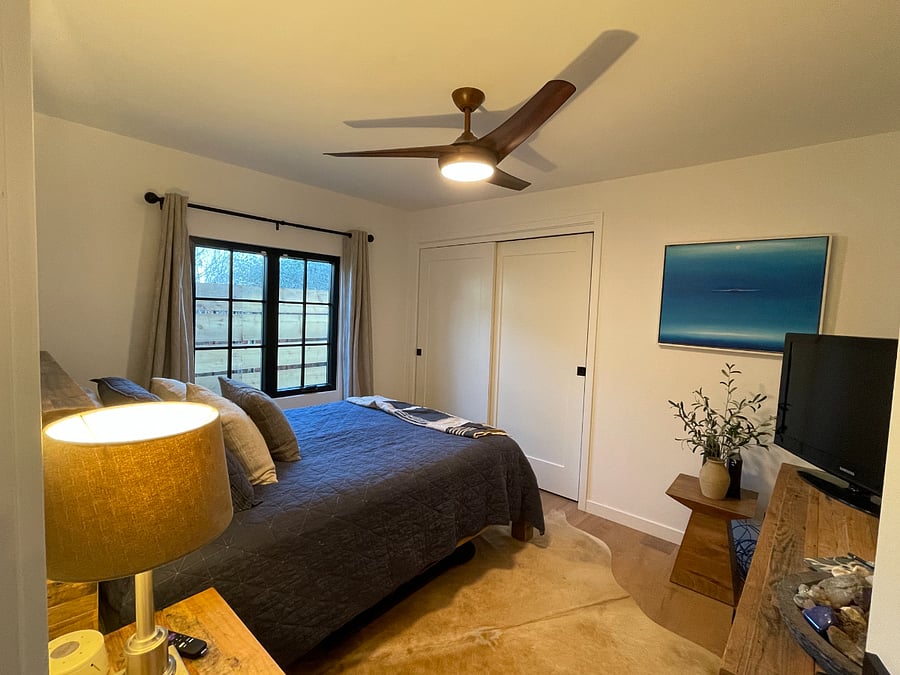 Primary bedroom with queen bed and TV.