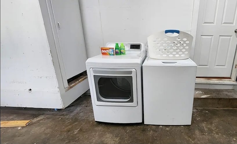 The laundry room shares the same space as the garage. Nearby are other amenities like cleaning supplies and a first aid kit.