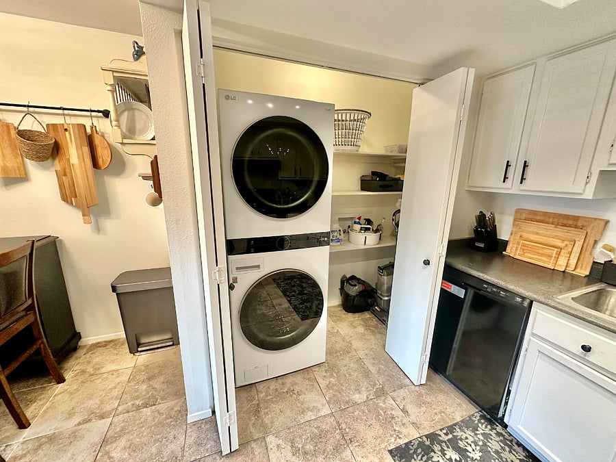 Stacked washer dryer units and extra storage space which doubles as a cleaning closet or could be used as a pantry