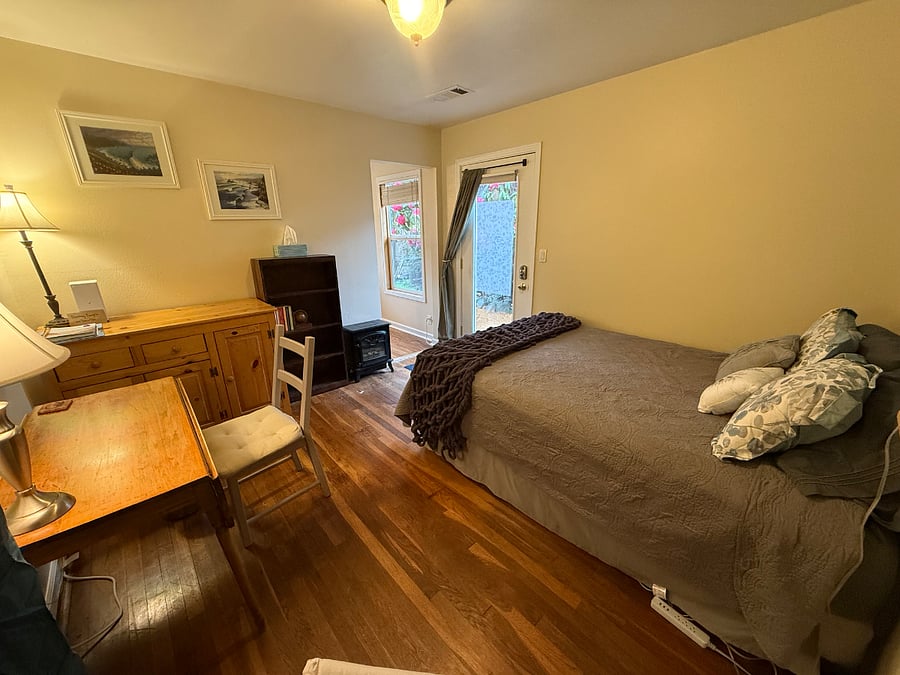 Main room. Queen bed, workspace table, reading chair, and storage. mai
