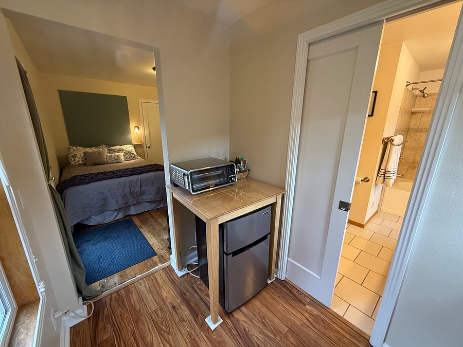 view of full bath and main room from kitchenette