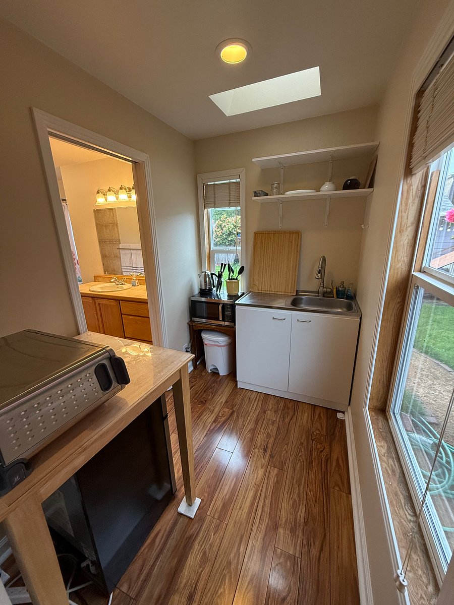 Kitchenette with sink, toaster over/air fryer, small fridge with separate freezer, microwave, table top single electric burner, and blender