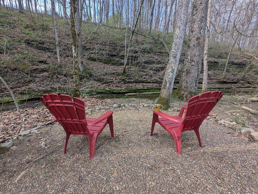 Peaceful seating area with small firepit overlooking the creek