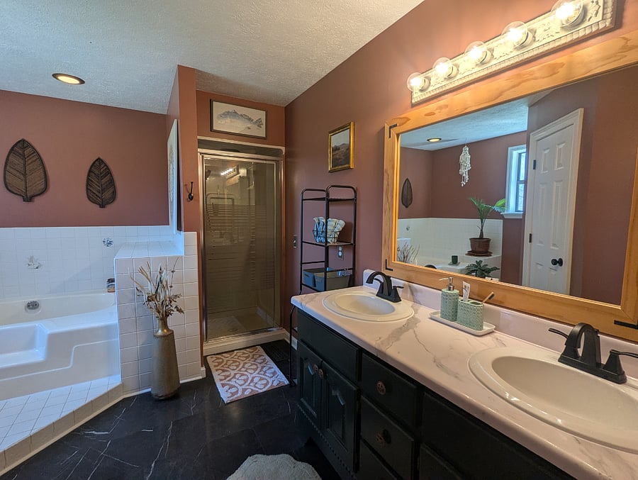 The master bathroom features a walk-in shower, a large soaking tub, and a double vanity. 
