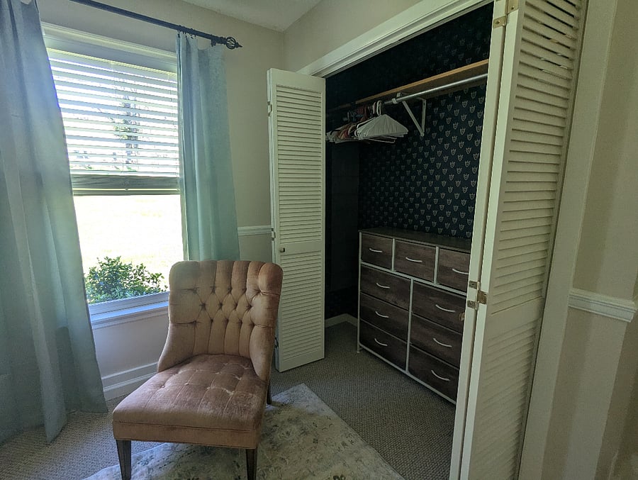 An accent chair and closet with dresser add extra space.