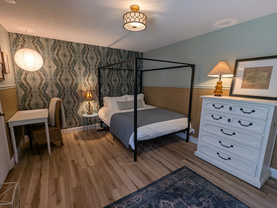 The third bedroom features a queen bed, a small writing desk, and a dresser. 