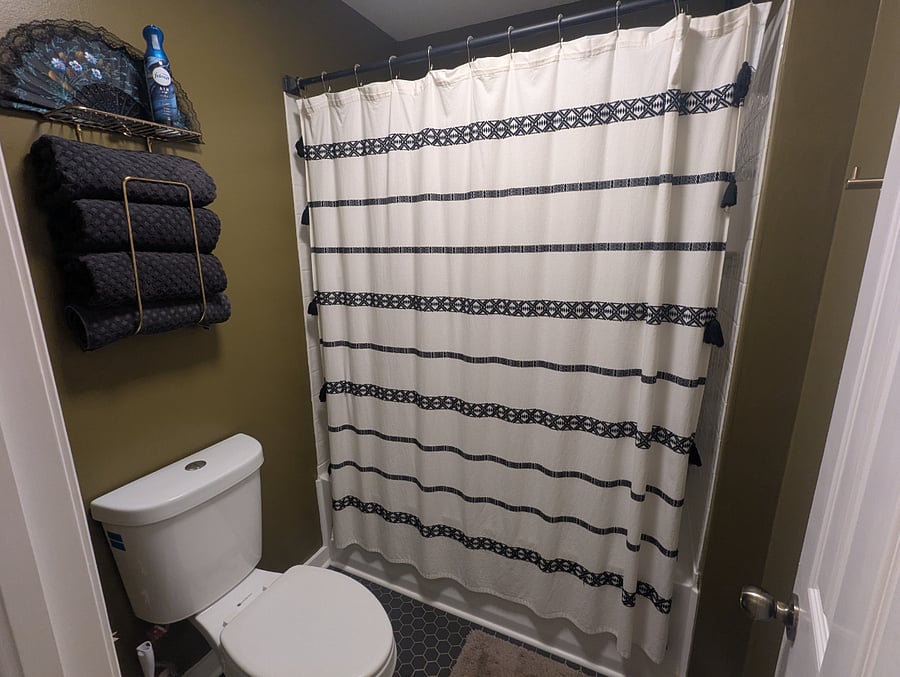 The bathroom has a standing shower/tub and toilet