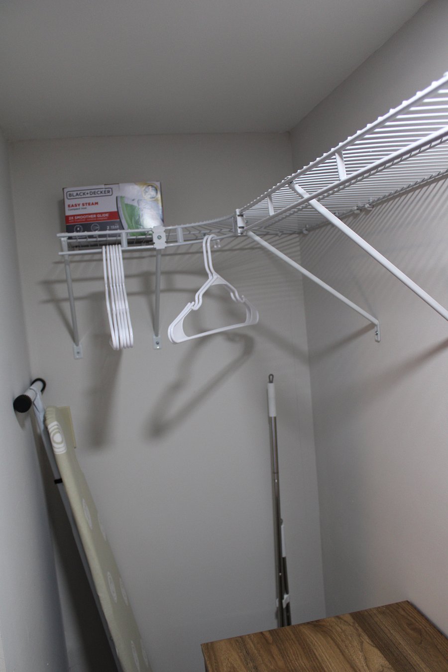 Hanging shelves, ironing board, iron, broom / dustpan.