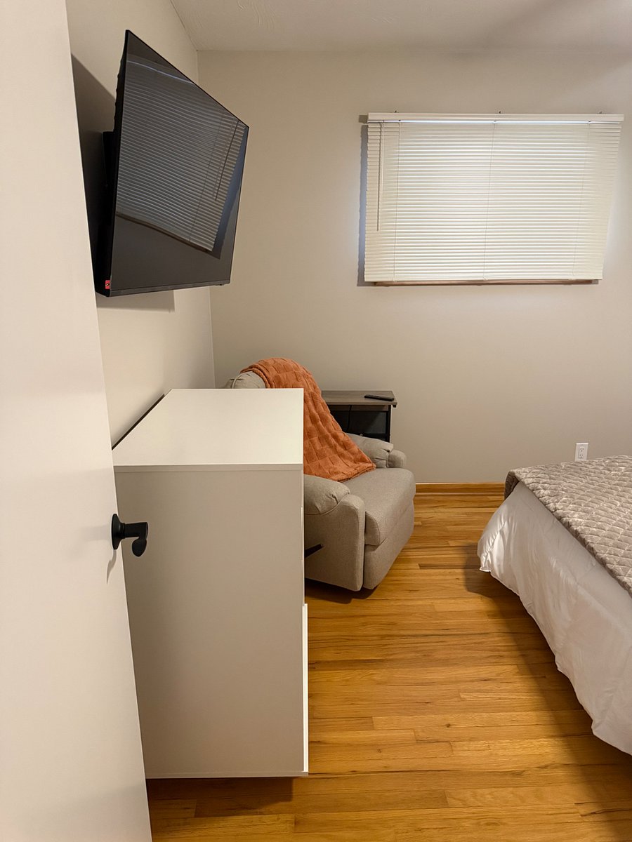 Dresser, TV and recliner with side table for electronics.