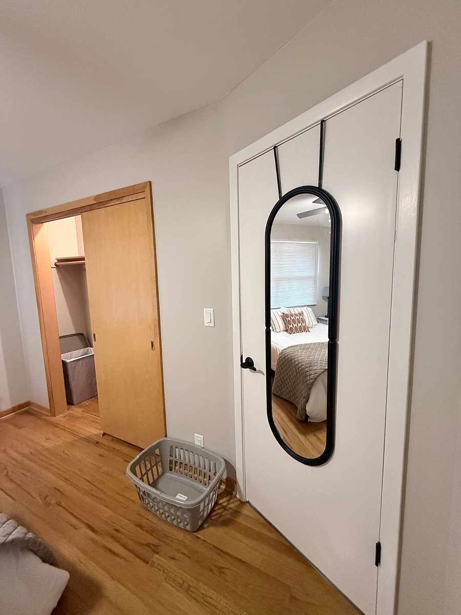 Closet and full-length mirror in bedroom.