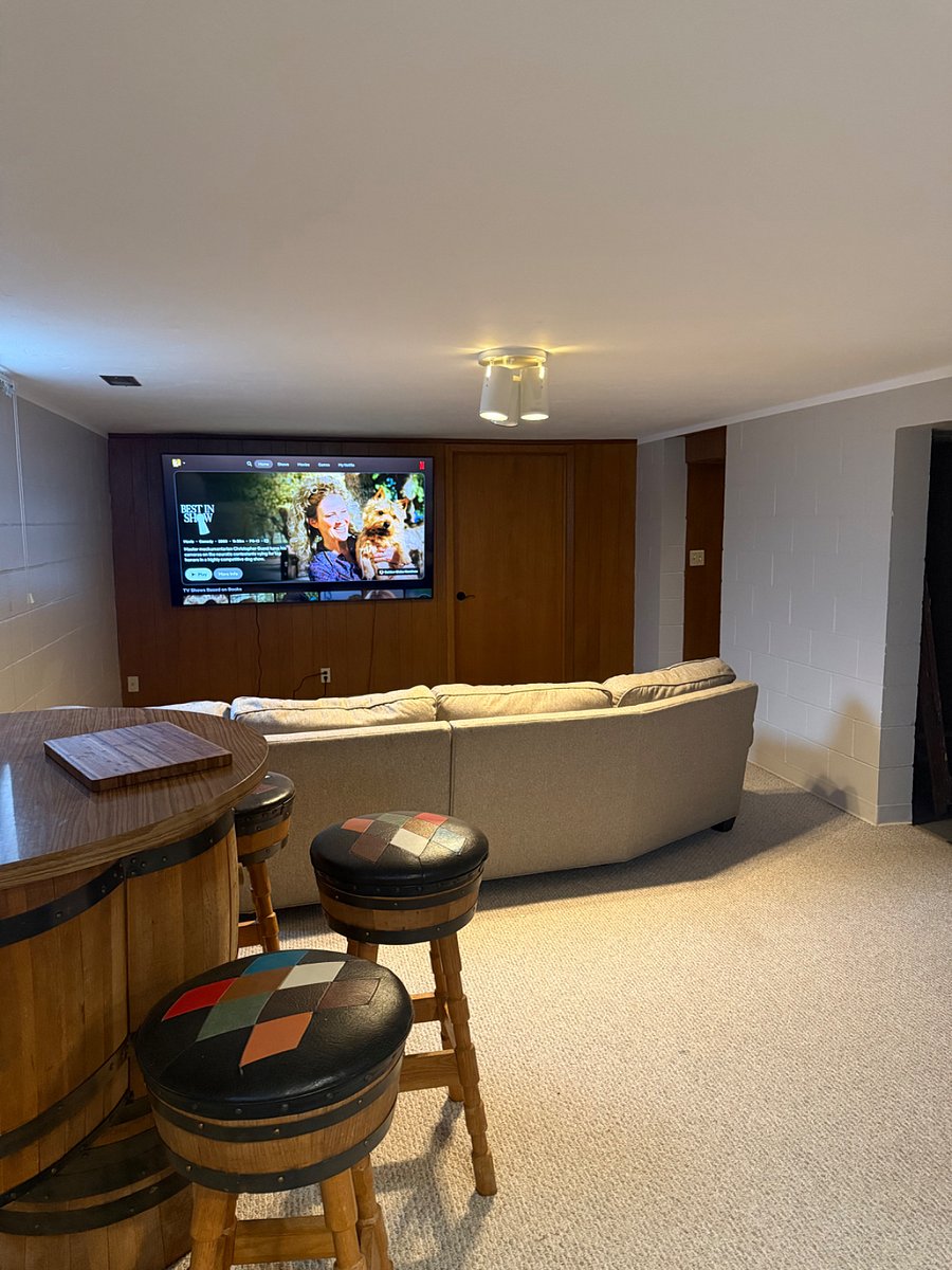 Additional living space in basement with comfy couch, bar and TV.