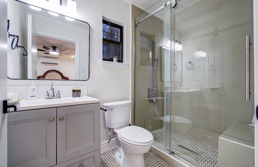 Ensuite bathroom with standing shower and rain head shower panel, bench