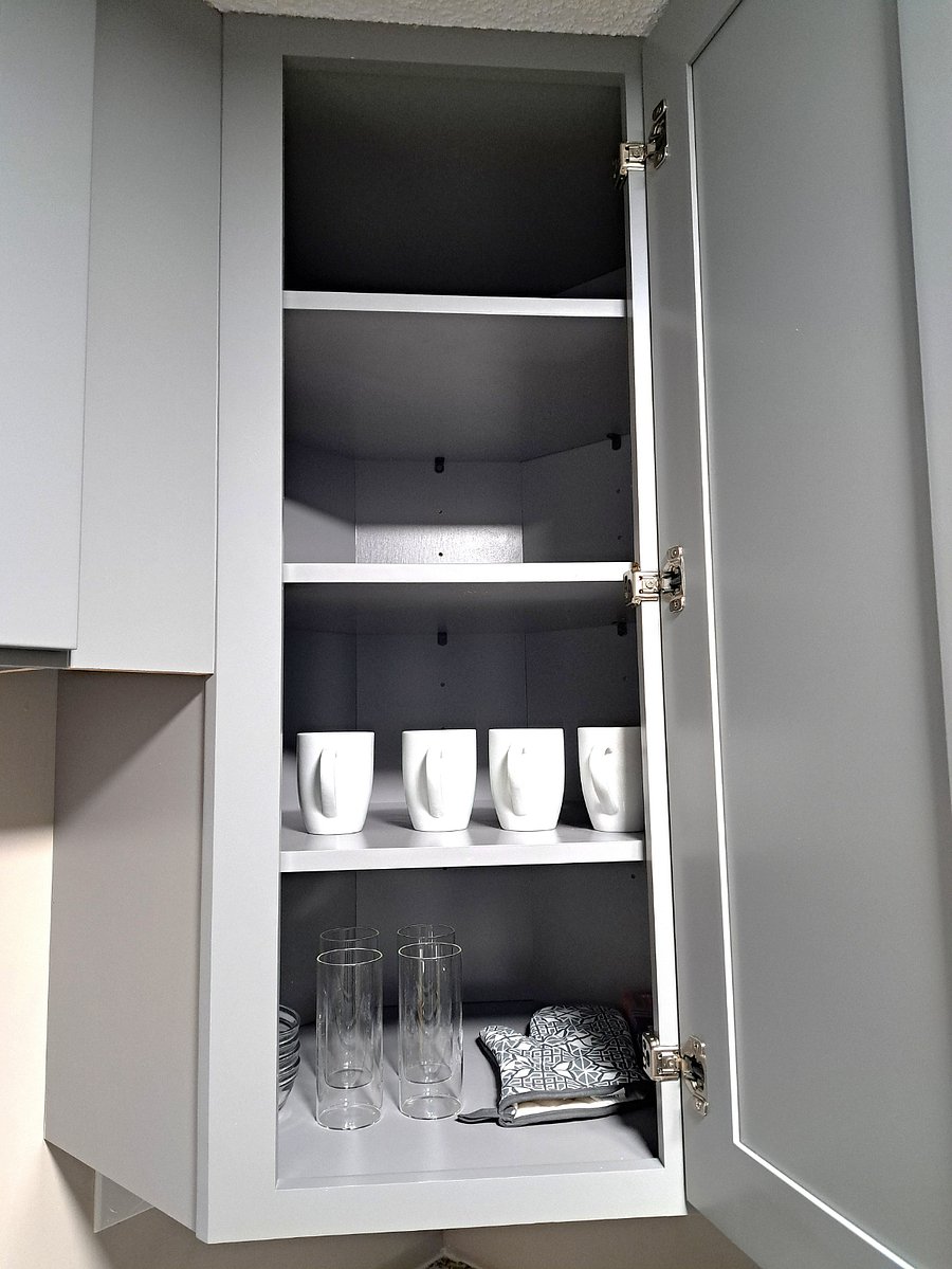 A fully stocked kitchen is equipped with all the essentials needed for meal preparation and entertaining. Modern Grey cabinets house a variety of cookware, such as pots, pans, and baking dishes, along with a full range of utensils like a set of 4 plates, quarter plates, cups, wine glasses, mugs, including knives, spatulas, oil bottles storage containers and measuring cups. Additionally, small appliances like a toaster, blender, and coffee maker are readily available, ensuring comfort and versatility for all cooking tasks. Dishwashing liquid along with a dish drainer rack are provided for added convenience. Luxurious Stainless-Steel Microwave, Range and a refrigerator are installed in the kitchen. 