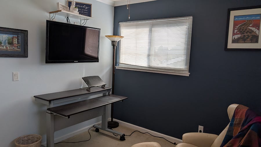 Sitting room with TV, desk, and closet.