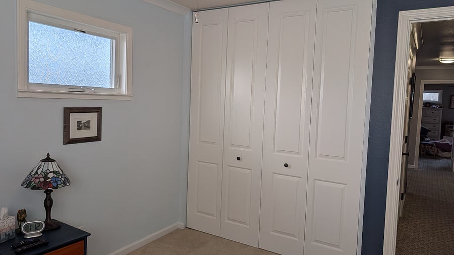 Sitting room with TV, desk, and closet.
