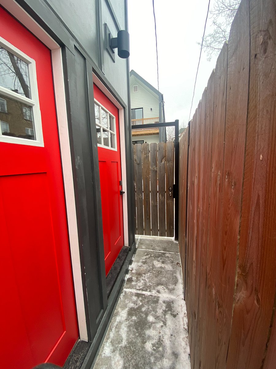 View of coach house unit entry (second red door, near wood gate). Fully private and separate entry from primary building.