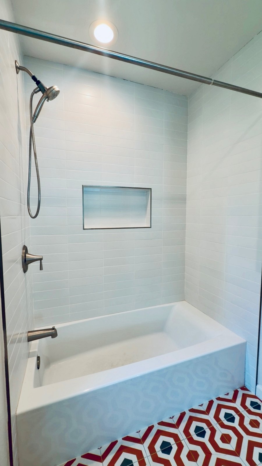 Clean, modern bathroom with full bathtub and shower,  perfect for relaxing after a long day.
