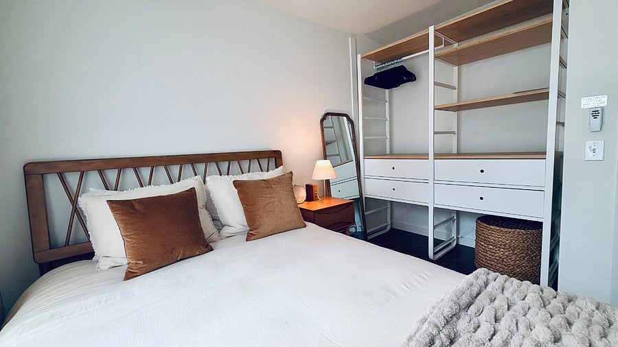 Bedroom includes open closet system with ample storage, shelving, and drawers 