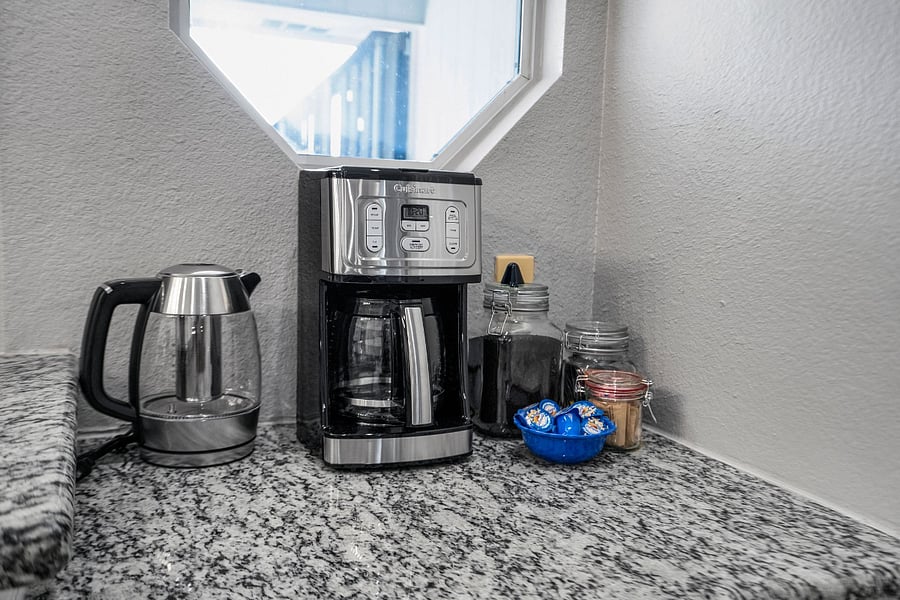 Coffee and tea service located at a small desk and bar set up in the kitchen