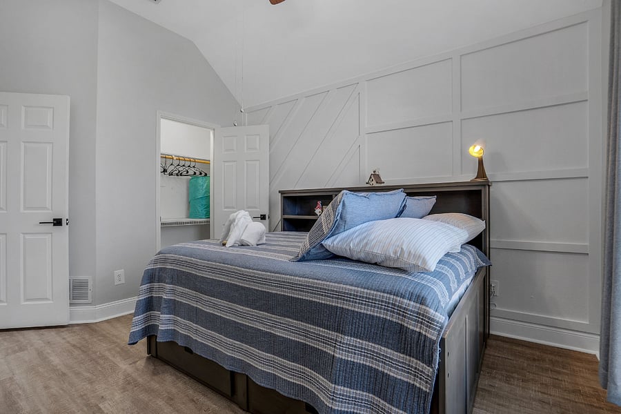 Full size bed with walk in closet, ceiling fan and drawers built in base