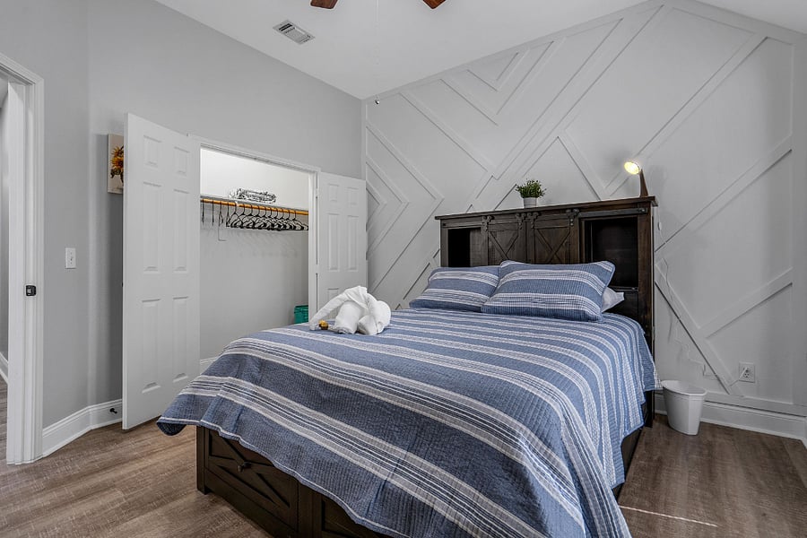 Queen bedroom with closet and ceiling fan and built in storage in base