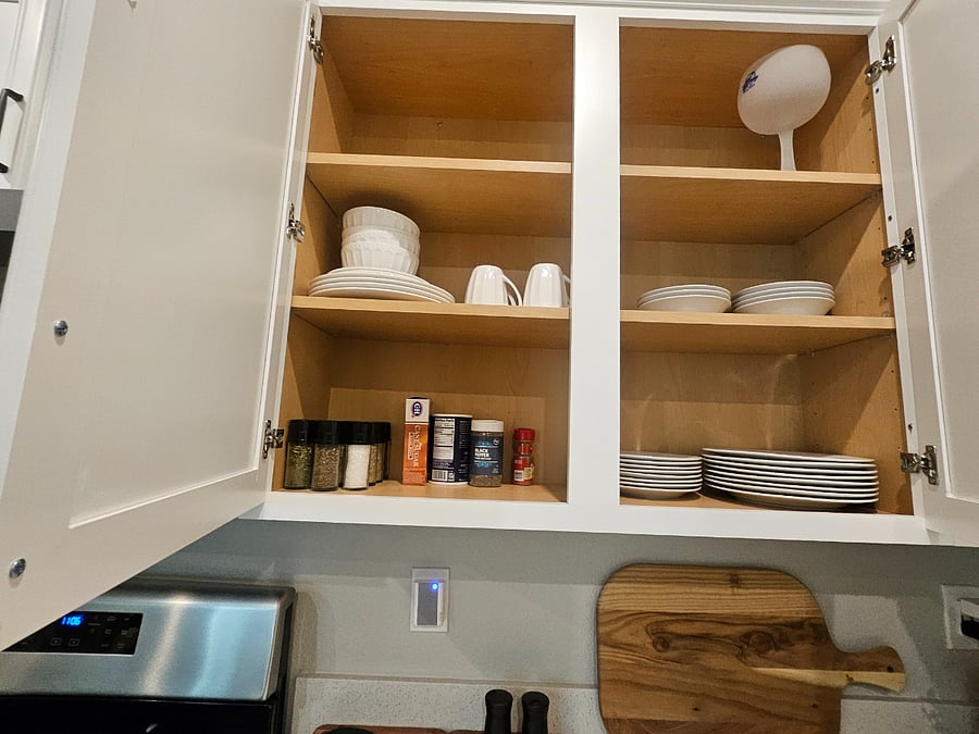 Kitchen has Dinnerware and spices for cooking